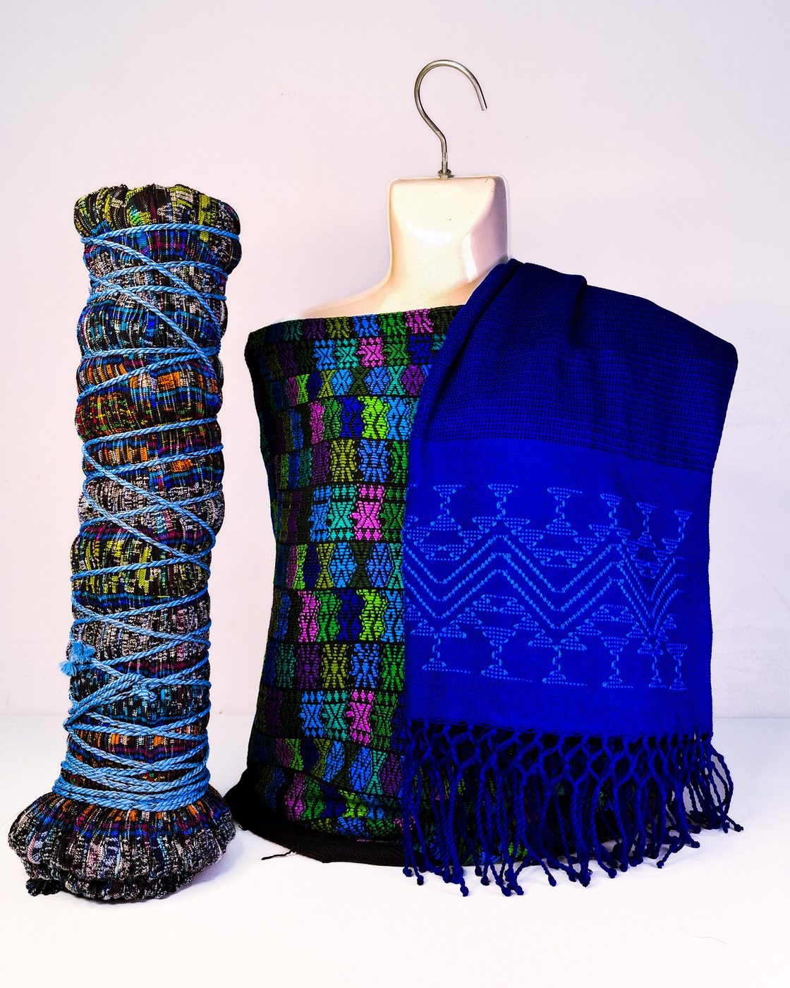 Conjunto con textil de bloques de color, chal azul rey bordado y una pieza enrollada con cordón azul